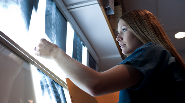 Medical professional looking at x-rays of light box